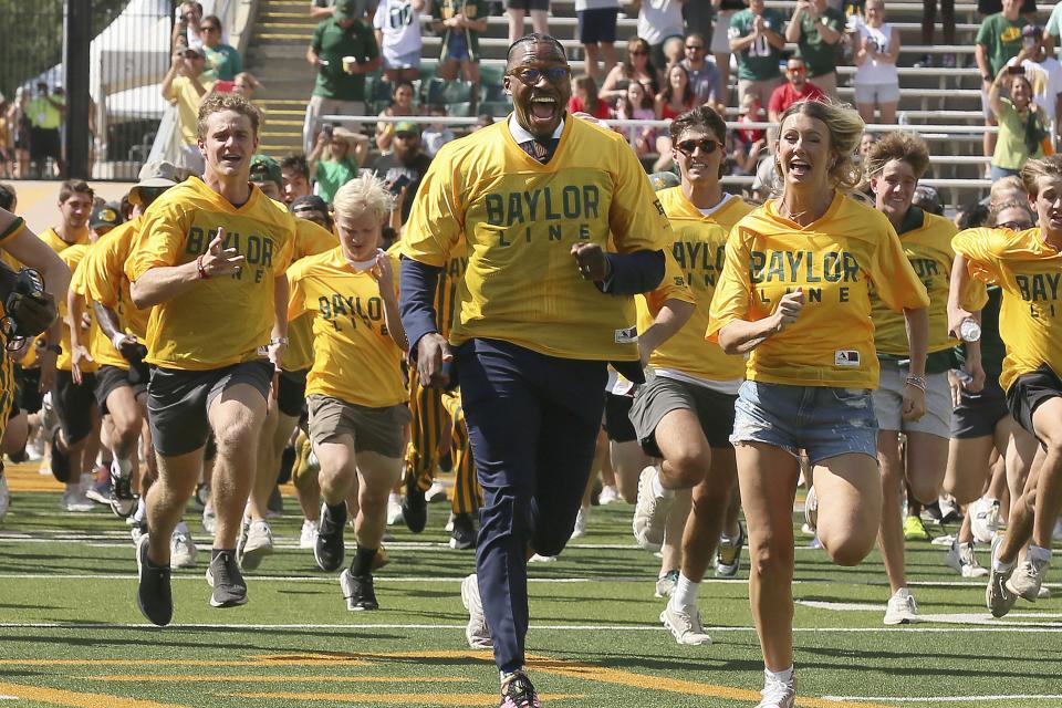 ESPN college football and NFL analyst and former Baylor Heisman quarterback Robert Griffin III runs onto the field with the Baylor line in an NCAA college football game against Utah, Saturday, Sept. 9, 2023, in Waco, Texas. (AP Photo/Jerry Larson) | AP