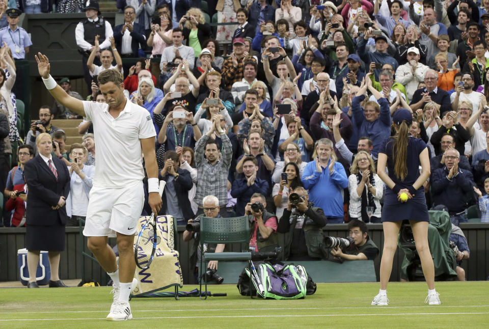 FILE - Marcus Willis, of Britain, waves to the crowds after losing to Roger Federer, of Switzerland, in their men's singles match on day three of the Wimbledon Tennis Championships in London, in this Wednesday, June 29, 2016, file photo. Willis, the Everyman’s everyman who was ranked 772nd when he faced Roger Federer at Wimbledon in 2016, is ending his playing career and focusing on coaching tennis to try to show youngsters “that anyone can live the dream.” (AP Photo/Tim Ireland, File)