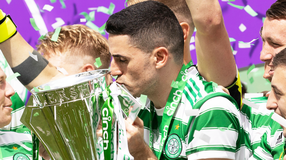 Celtic star Tom Rogic (pictured) kisses the trophy.