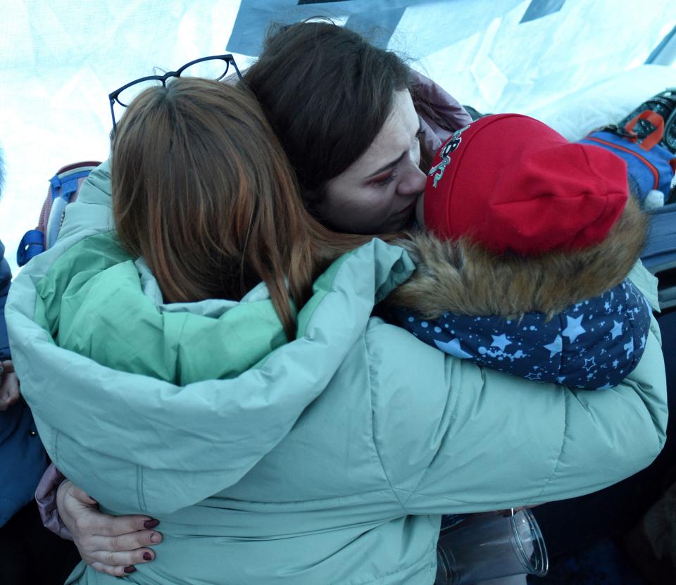 Women hug as they stand inside a tent set near Lviv main railway station in Western Ukraine. European stocks joined a global sell-off as the Ukrain crisis deepends. Photo: Yuriy Dyachyshyn / AFP via Getty Images