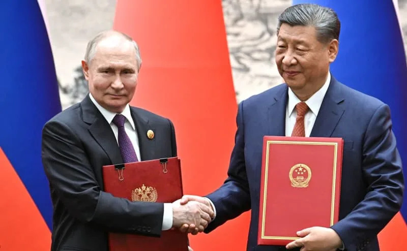 Russian President Vladimir Putin (L) and Chinese President Xi Jinping shake hands after signing a joint statement on deepening relations of comprehensive partnership and strategic interaction. Putin is on a two-day state visit to China. -/Kremlin/dpa