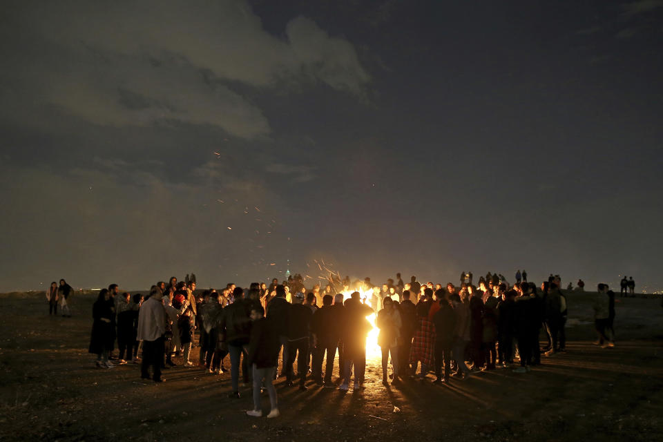 Iranians light fireworks during a celebration, known as "Chaharshanbe Souri," or Wednesday Feast, marking the eve of the last Wednesday of the solar Persian year, Tuesday, March 19, 2019 in in Tehran, Iran. Iran's many woes briefly went up in smoke on Tuesday as Iranians observed a nearly 4,000-year-old Persian tradition known as the Festival of Fire. (AP Photo/Ebrahim Noroozi)