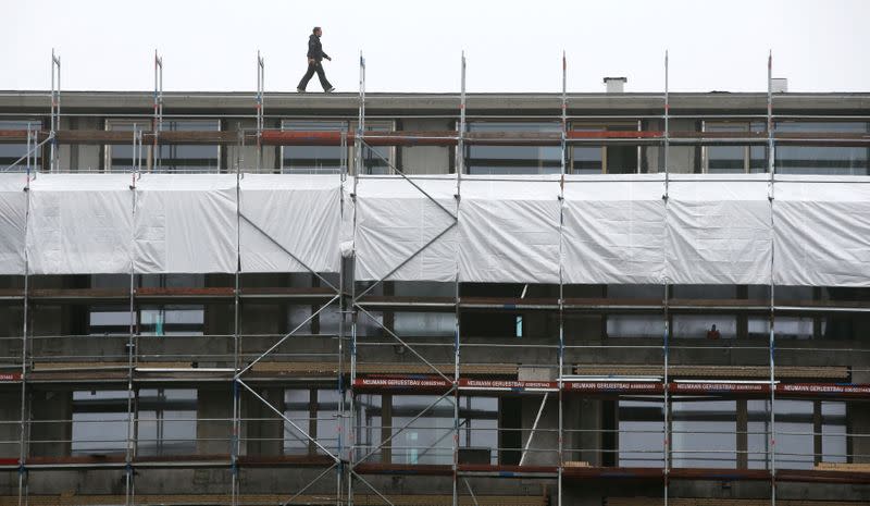 A worker walks on scaffoldings at an apartment building in Berlin