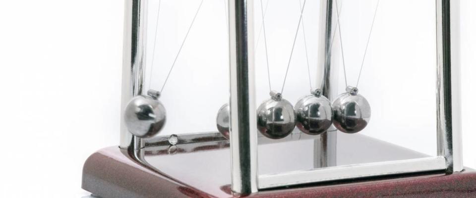 Old momentum pendulum on white background.