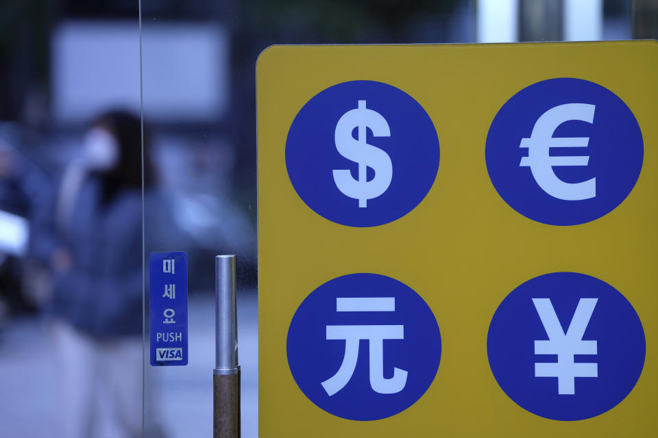 A woman wearing a face mask walks past near a money exchange office in downtown Seoul, South Korea, Friday, Nov. 12, 2021. Shares were mostly higher in Asia on Friday after Wall Street benchmarks managed to close mostly higher. (AP Photo/Lee Jin-man)