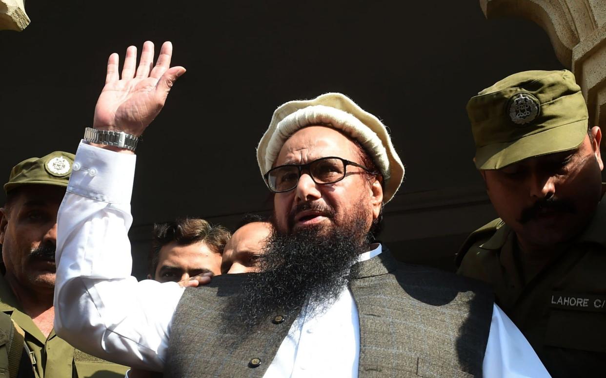 Hafiz Saeed waves to supporters as he leaves a court in Lahore - AFP