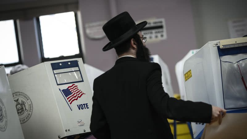 A member of the Orthodox Jewish community walks toward the privacy booth to fill out ballot at a polling center on, Tuesday, Nov. 8, 2022, in the Brooklyn borough of New York. 
