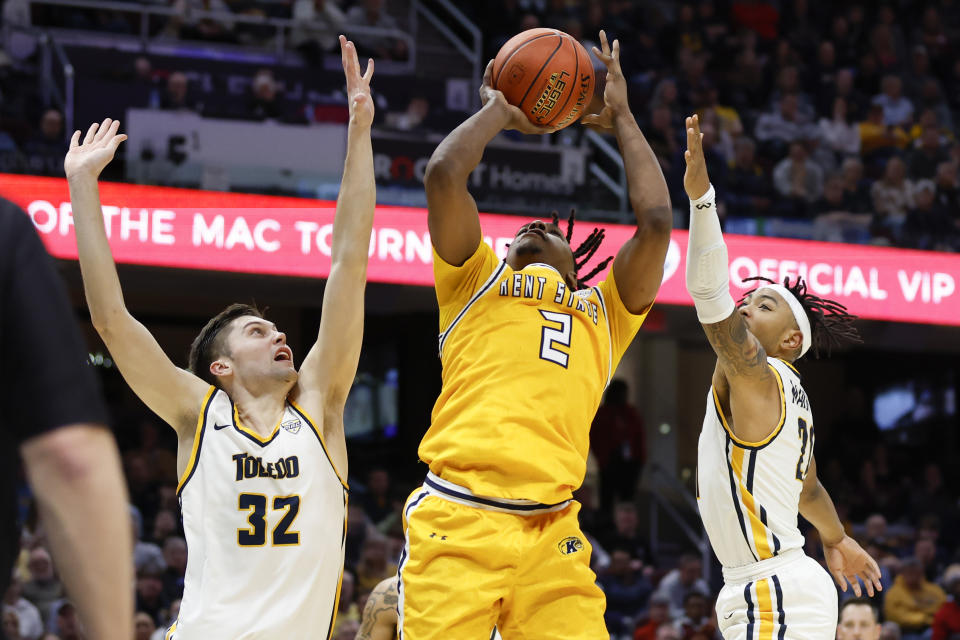 Kent State guard Malique Jacobs (2) shoots against Toledo forward JT Shumate (32) and guard Dante Maddox Jr. (21) during the first half of an NCAA college basketball game for the championship of the Mid-American Conference tournament, Saturday, March 11, 2023, in Cleveland. (AP Photo/Ron Schwane)