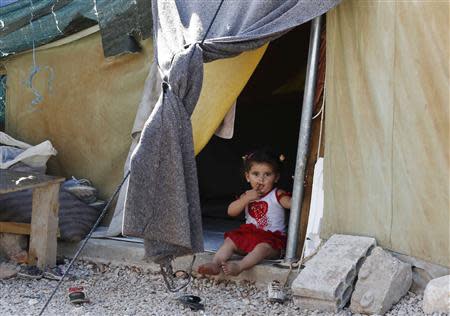 A Syrian refugee child who arrived with her family from Damascus, sits in her tent at the Majdal Anjar refugee camp in Bekaa Valley near the Syrian border in eastern Lebanon, September 9, 2013. REUTERS/Jamal Saidi