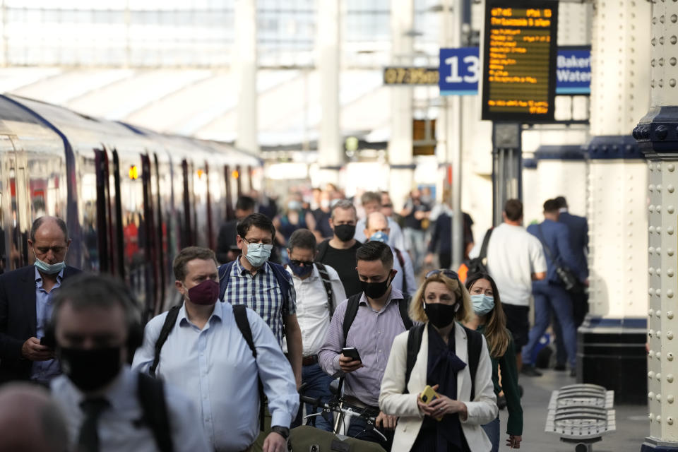 People wear face masks to curb the spread of coronavirus as they disembark from a train during the morning rush hour at Waterloo train station in London, Wednesday, July 14, 2021. London Mayor Sadiq Khan has asked Transport for London to enforce the use of mask wearing on buses and trains as a "condition of carriage", even after legal restrictions in England are lifted on July 19. Khan said he was "not prepared" to put tube, tram and other transport users in the capital "at risk" by removing the rules on face coverings. (AP Photo/Matt Dunham)