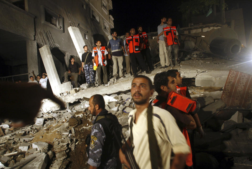 FILE - Palestinians gather in the rubble of a house destroyed in an explosion in Gaza City, early Wednesday, July 12, 2006. Israeli aircraft blasted the house and killed seven people in Gaza City early Wednesday, during a high-level meeting of Hamas commanders, Palestinians and the military said, as Israeli forces expanded their offensive in the southern Gaza Strip. (AP Photo/David Guttenfelder, File)