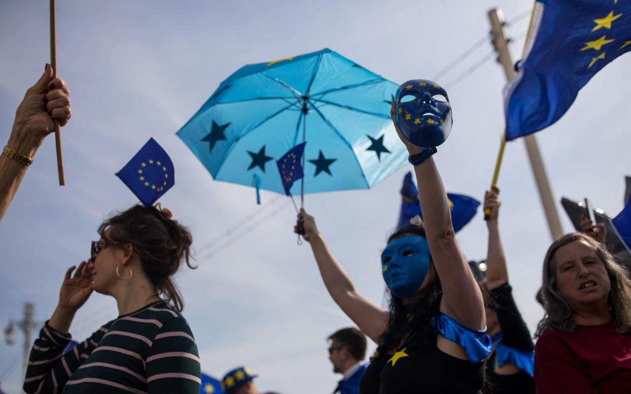 Pro-European Union campaigners walk with EU flags, umbrellas and masks - Bloomberg