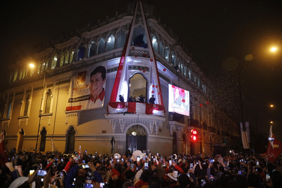 Pedro Castillo celebrates with his running mate Dina Boluarte after being declared president-elect of Peru by election authorities, from the balcony of his campaign headquarters in Lima Peru, Monday, July 19, 2021. Castillo was declared president-elect more than a month after the elections took place and after opponent Keiko Fujimori claimed that the election was tainted by fraud. (AP Photo/Guadalupe Prado)