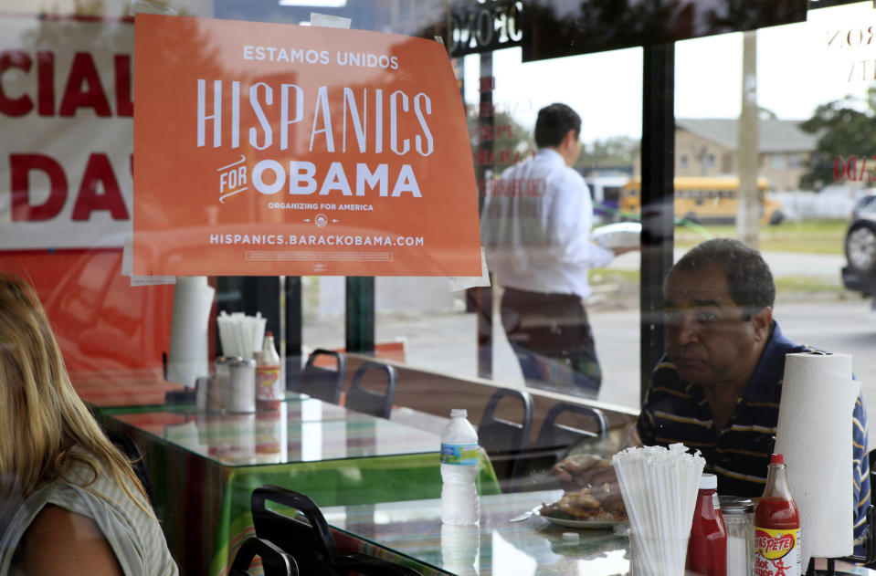 FILE - In this Oct. 26, 2012, file photo, Spanish language election campaign signs promoting President Barack Obama hang on the windows at Lechonera El Barrio Restaurant in Orlando, Fla. Hispanics supported President Barack Obama over Republican Mitt Romney by almost 3-to-1 and put Republicans on notice they must take real steps to win over the nation’s largest minority group if they want to win the presidency again. Exit polls say that Romney, who has backed hardline immigration measures, won only 27 percent of Hispanics. (AP Photo/Julie Fletcher)