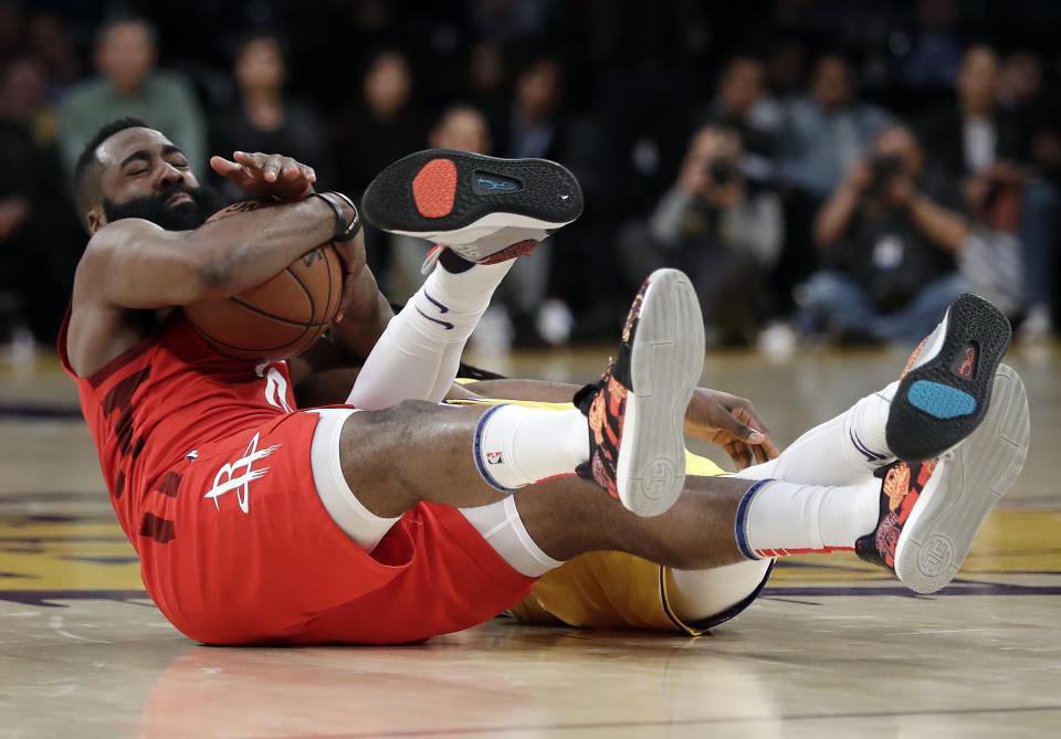 Houston Rockets' James Harden, left, reaches for a loose ball next to Los Angeles Lakers' Reggie Bullock during the second half of an NBA basketball game Thursday, Feb. 21, 2019, in Los Angeles. (AP Photo/Marcio Jose Sanchez)
