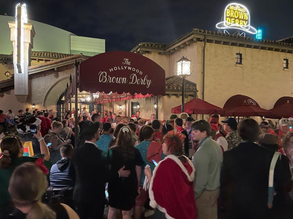 At 8:15 p.m. on opening night of Jollywood Nights at Disney's Hollywood Studios, crowds of guests thronged the entrance to The Hollywood Brown Derby after joining the mobile walk-up list on the My Disney Experience app.