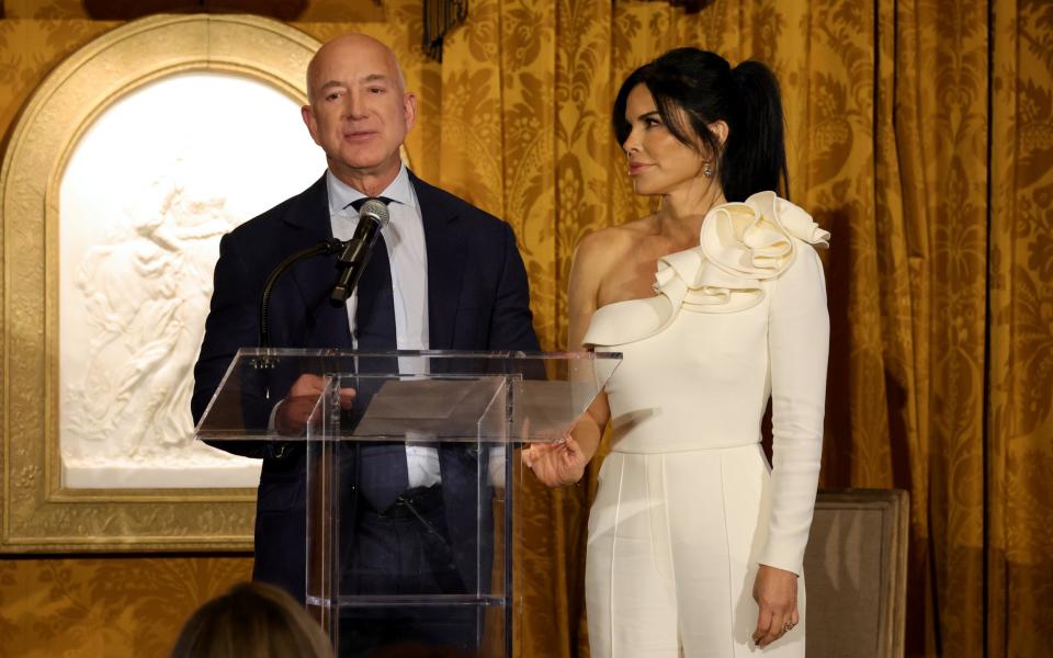 Jeff Bezos and Lauren Sanchez speak on stage during the IWMF Courage in Journalism Awards in Washington, October 2023