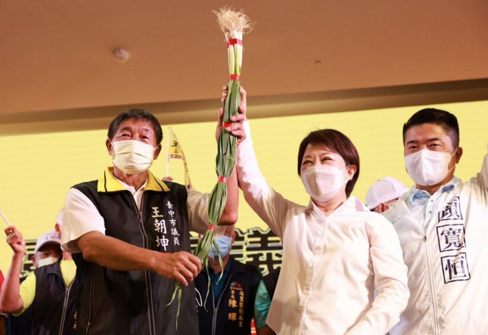 台中市長盧秀燕昨日為市議員候選人王朝坤站台，兩人共拿一把青蔥象徵合作向前衝，現場「凍蒜」聲不斷。（記者陳金龍攝）
