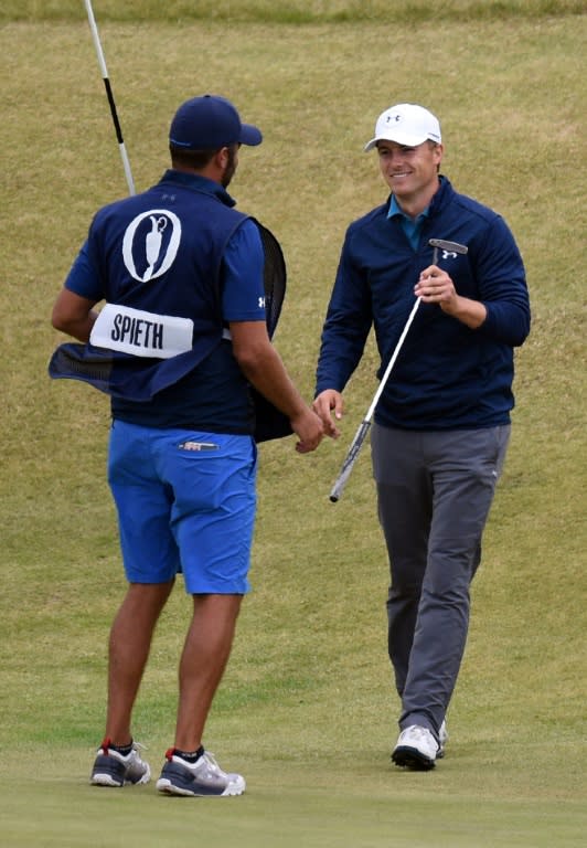 US golfer Jordan Spieth (R) and his caddie Michael Greller celebrate on the 18th green