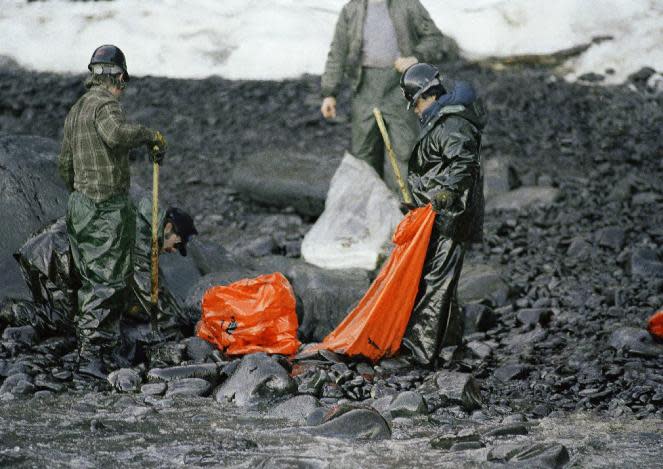 FILE - In this April 2, 1989, file photo, workers try to remove globs of oil from Baked Island in Prince William Sound, Alaska. A massive oil slick covers Prince William Sound stretching over 100 miles as the result of the tanker Exxon Valdez running aground March 24, 1989, spilling more than 10-million gallons of oil. Nearly 25 years after the Exxon Valdez oil spill off the coast of Alaska, some damage heals, some effects linger in Prince William Sound. (AP Photo/Jack Smith, File)