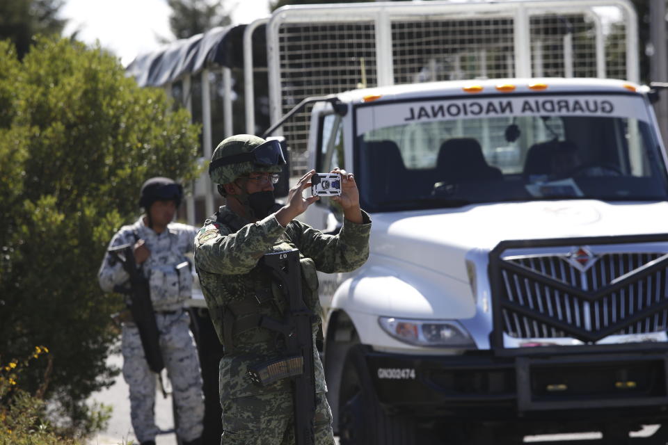 A Mexican military person takes photos outside the Almoloya prison where Ovidio Guzman, the son of imprisoned drug lord Joaquin “El Chapo” Guzman, is being held in Villa de Almoloya de Juarez, Mexico, Friday, Jan. 6, 2023. (AP Photo/Ginnette Riquelme)