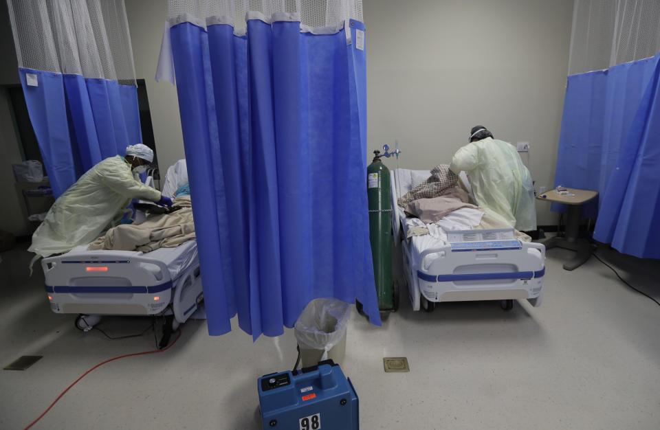 Medical personnel watch over COVID-19 patients at DHR Health, Wednesday, July 29, 2020, in McAllen, Texas. At DHR Health, the largest hospital on the border, roughly half of the 500 beds belong to coronavirus patients isolated in two units. A third unit is in the works. (AP Photo/Eric Gay)