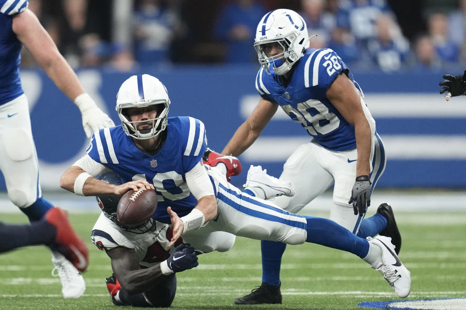 Indianapolis Colts quarterback Gardner Minshew (10) is tackled by Houston Texans linebacker Christian Harris (48) during the first half of an NFL football game Saturday, Jan. 6, 2024, in Indianapolis. (AP Photo/Michael Conroy)