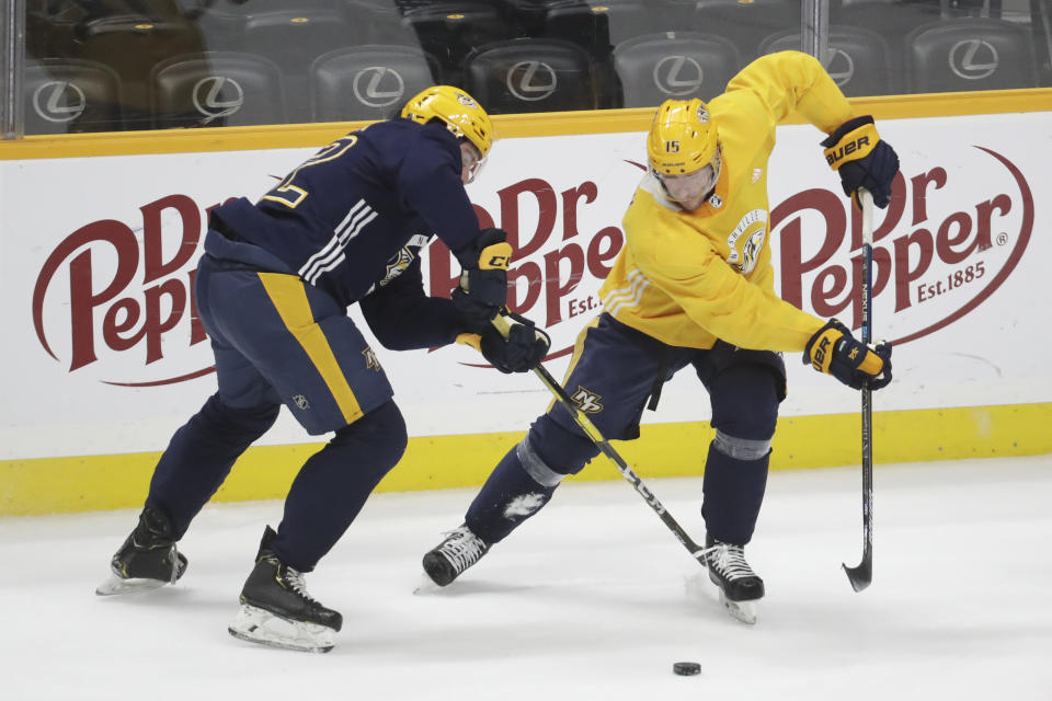 Nashville Predators center Yakov Trenin, of Russia, left, and right wing Craig Smith (15) battle for the puck during NHL hockey training camp Tuesday, July 14, 2020, in Nashville, Tenn. (AP Photo/Mark Humphrey)