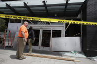 People work outside a Target store damaged from protests over the Memorial Day death of George Floyd, a handcuffed black man in police custody in Minneapolis, in Oakland, Calif., Saturday, May 30, 2020. (AP Photo/Jeff Chiu)