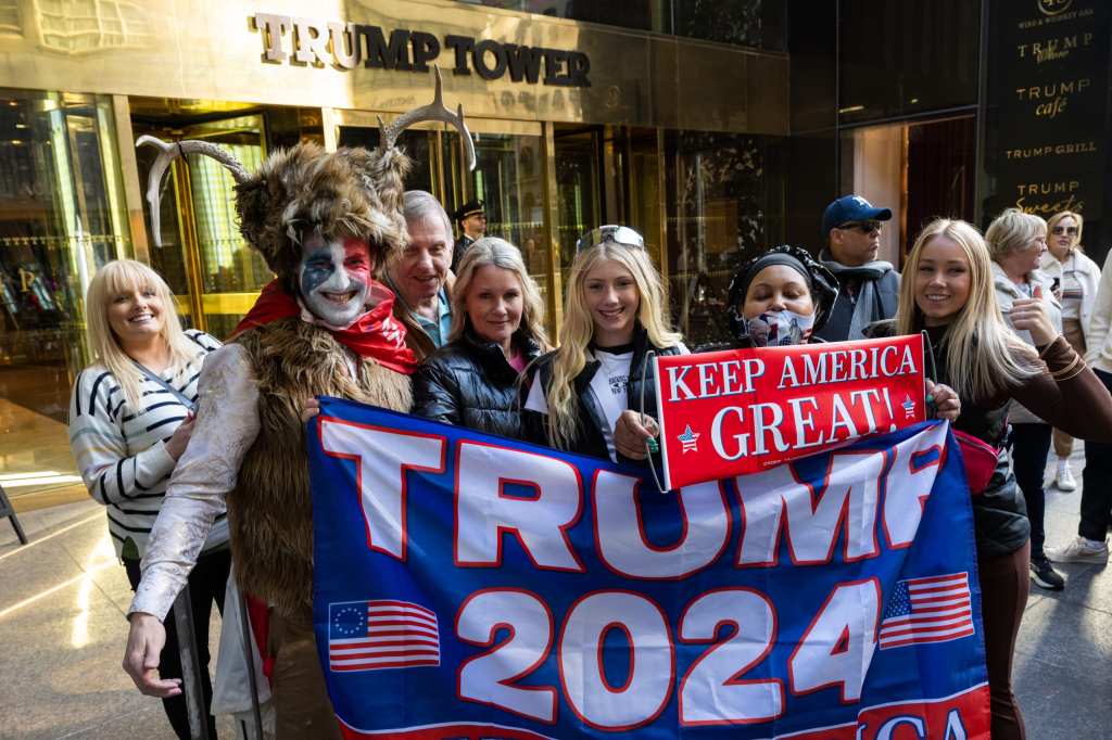 Supporters of former President Donald J. Trump pose with a demonstrator who identifies himself as Steven Daniel Wolverton dressed like the Q-Anon Shaman outside Trump Tower on March 21, 2023 in New York, New York. (Photo by Alexi Rosenfeld/Getty Images)