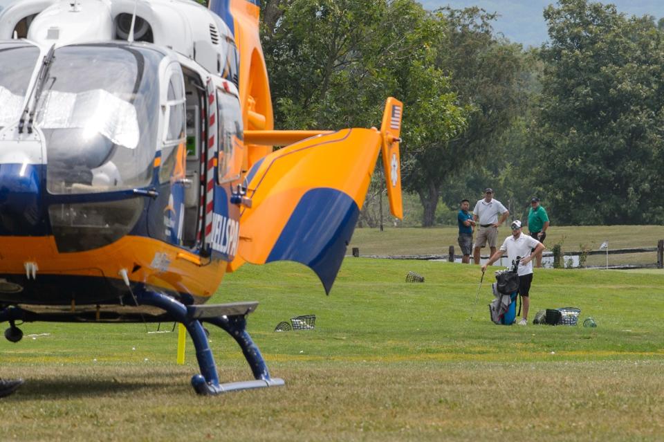 Golfers at the Bridges Golf Course look towards a medical helicopter on the green at the scene where a man was heavily entrapped inside a minivan after a crash on Route 30, Friday, Aug. 2, 2024, in Berwick Township.