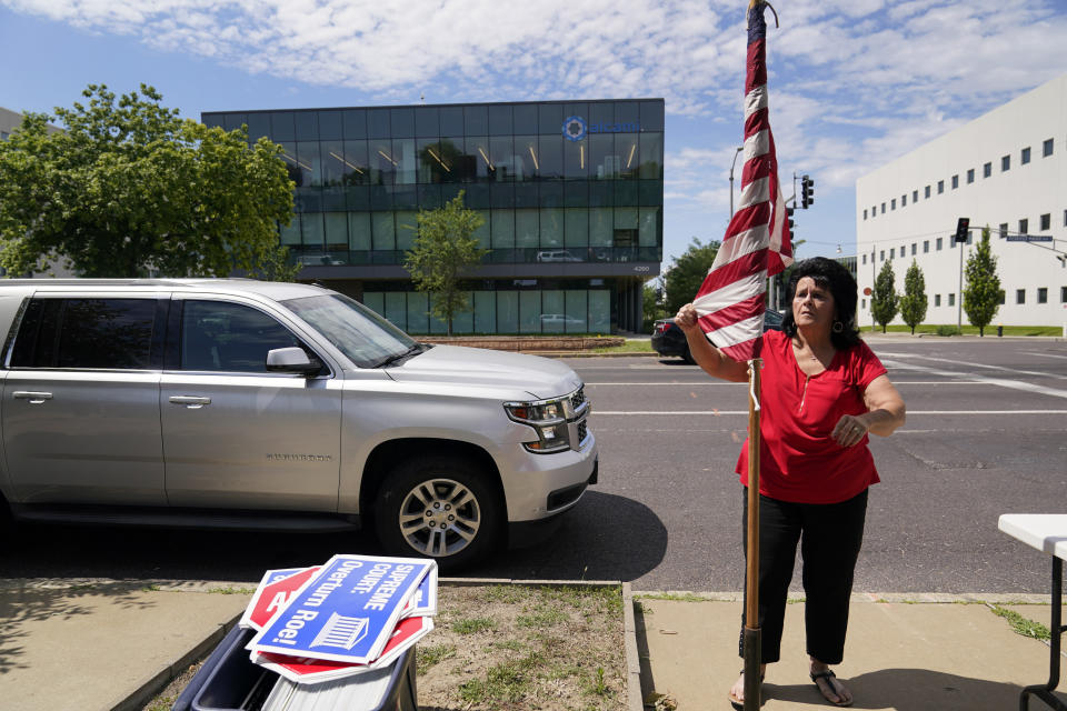 Defenders of the Unborn founder Mary Maschmeier, unfurls a U.S. flag outside Planned Parenthood Friday, June 24, 2022, in St. Louis. The Supreme Court has ended constitutional protections for abortion that had been in place nearly 50 years — a decision by its conservative majority to overturn the court's landmark abortion cases. Friday’s outcome overturning Roe v. Wade is expected to lead to abortion bans in roughly half the states. (AP Photo/Jeff Roberson)