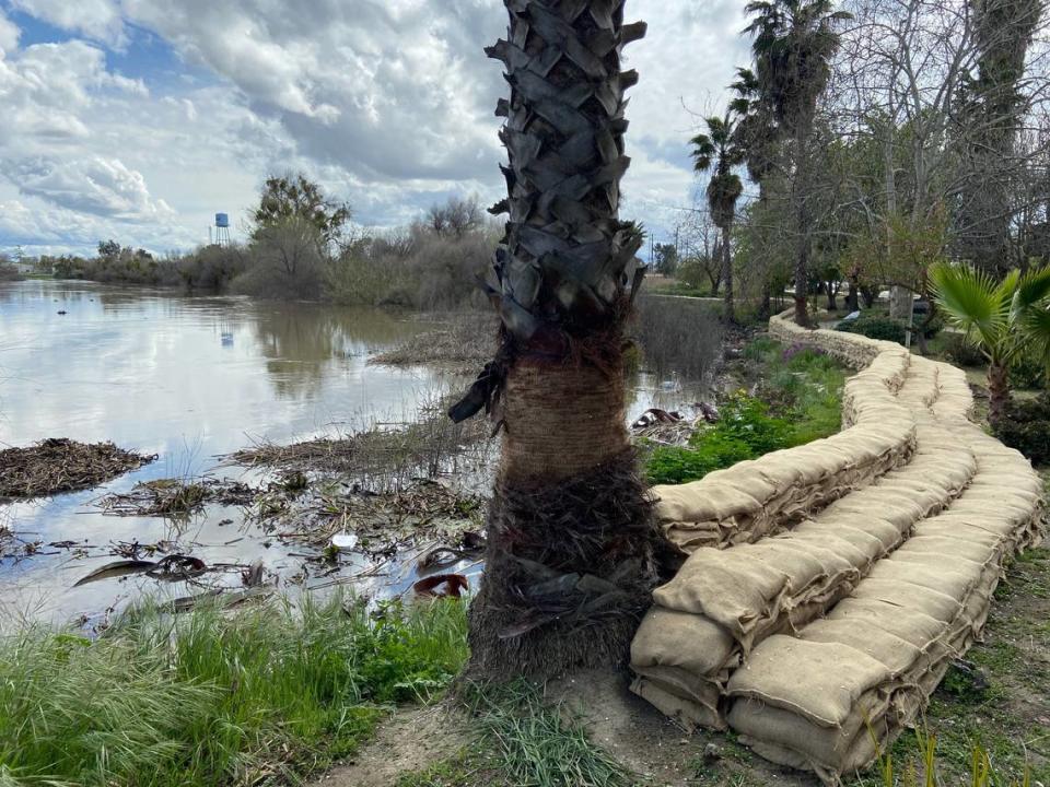 A wall of 6,000 sandbags protects the Firebaugh Riverfront Inn and nearby homes from the rising waters of the San Joaquin River on March 20, 2023. The motel was identified as a community low spot in a state survey.