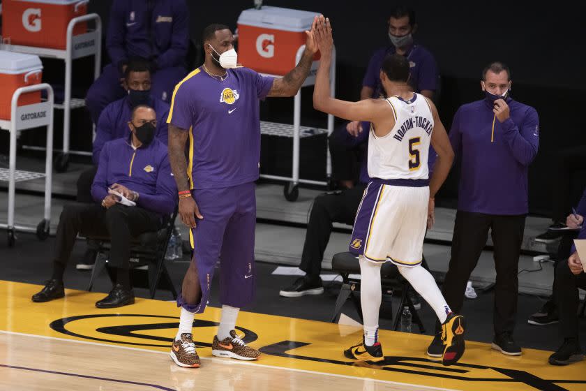 Los Angeles Lakers forward LeBron James, left, greets guard Talen Horton-Tucker.