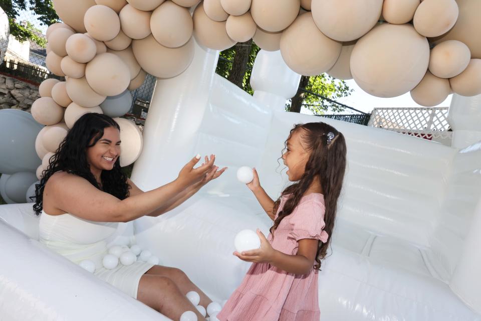 Jalani Jumps owner Nayara Barbosa of Brockton tries out one of her bounce houses with her daughter Jalani on Saturday, June 25, 2022.