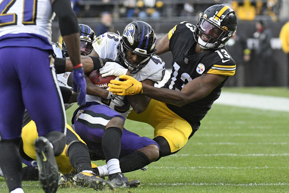 Baltimore Ravens running back Justice Hill is tackled by Pittsburgh Steelers wide receiver Miles Boykin during the second half of an NFL football game in Pittsburgh, Sunday, Dec. 11, 2022. The Ravens won 16-14. (AP Photo/Don Wright)