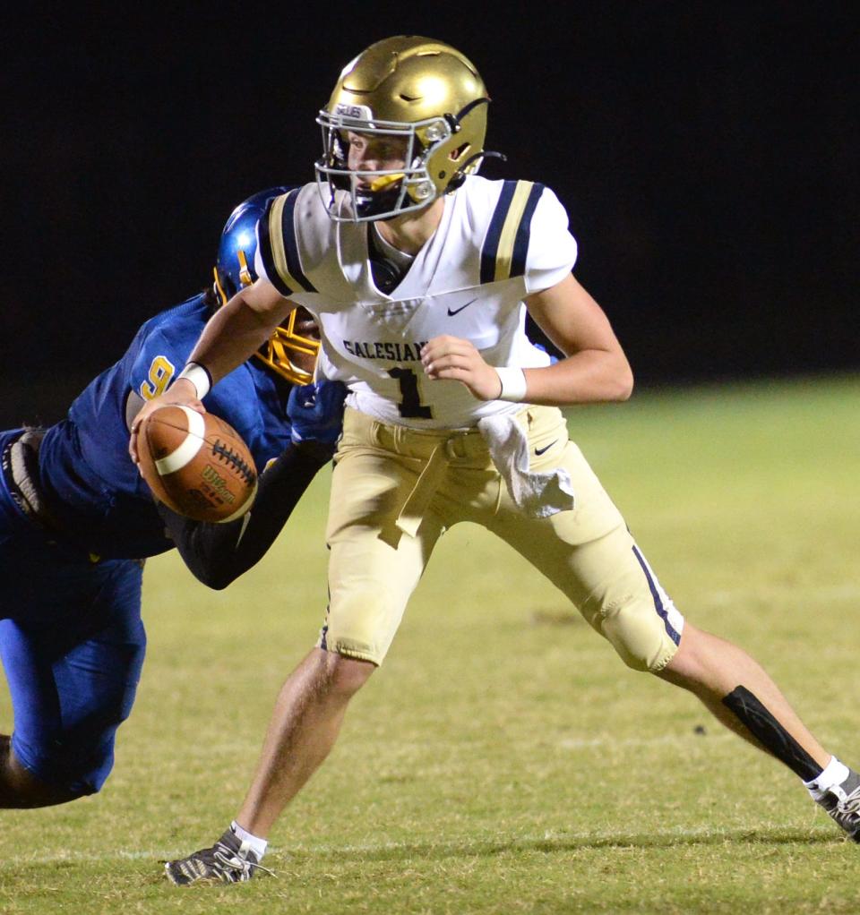 Salesianum quarterback Ryan Stoehr scrambles in the backfield trying to get away from Sussex Central defender Kevon Moore-Briddell, Friday, Sept. 9, 2022. Sussex Central won, 7-0.