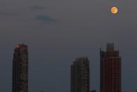 The moon is pictured one day ahead of the Supermoon phenomenon as it rises over buildings in Long Island City, seen from a bridge over 42nd St. in the Manhattan borough of New York July 11, 2014. Occurring when a full moon or new moon coincides with the closest approach the moon makes to the Earth, the Supermoon results in a larger-than-usual appearance of the lunar disk.