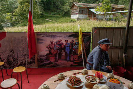 A participant dressed in replica red army uniform waits for lunch during a Communist team-building course extolling the spirit of the Long March, organised by the Revolutionary Tradition College, in the mountains outside Jinggangshan, Jiangxi province, China, September 14, 2017. REUTERS/Thomas Peter