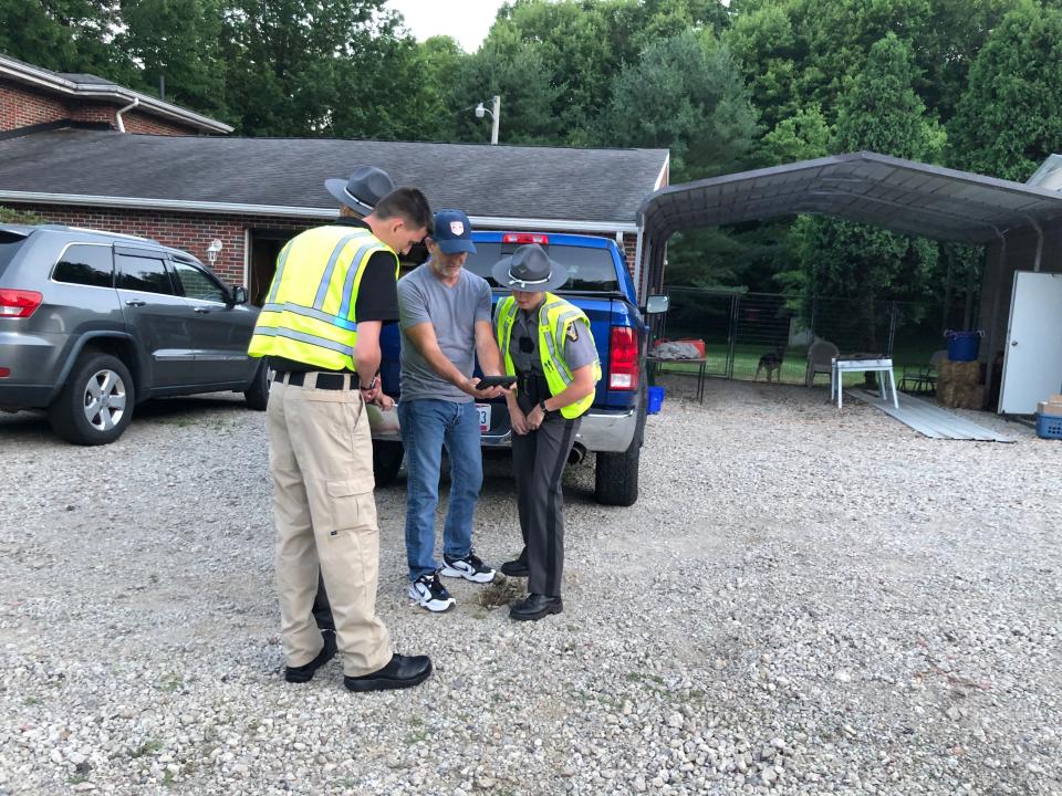 Walt Hall shows Ohio Highway Patrol troopers the video from his surveillance camera of the fatal head-on crash that took place Thursday evening in front of his home on U.S. Route 30 in Osnaburg Township.