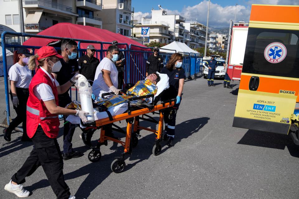 Paramedics carry an injured survivor of a shipwreck to an ambulance at a port southwest of Athens on Wednesday, June 14, 2023.