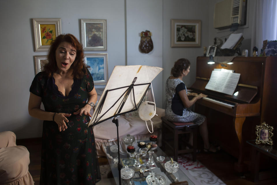 Municipal Theatre soprano opera singer Georgia Szpilman practices at her coach's home during the COVID-19 pandemic in Rio de Janeiro, Brazil, Thursday, March 25, 2021. Szpilman used to perform in the city’s majestic municipal theater that has been closed for over a year, but because she is technically a public servant, she was able to keep her salary from Rio’s state government while performing online. (AP Photo/Bruna Prado)