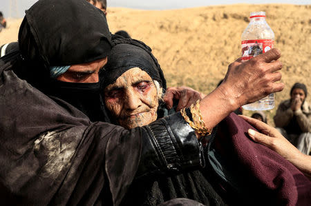 Khatla Ali Abdullah, 90, is embraced as she flees her home as Iraqi forces battle with Islamic State militants in western Mosul, Iraq February 27, 2017. REUTERS/Zohra Bensemra