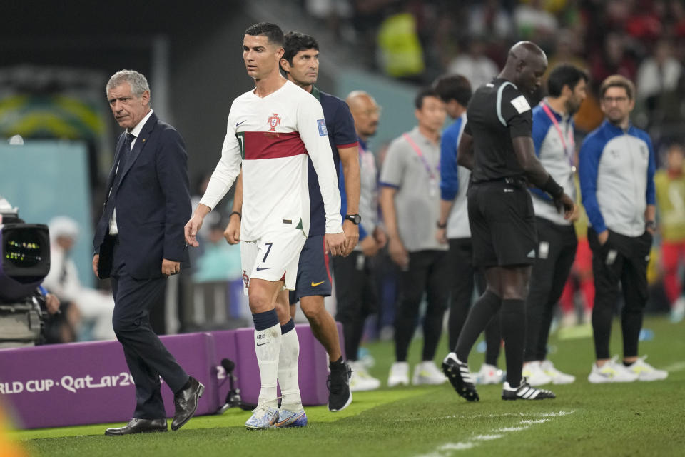 Portugal's Cristiano Ronaldo, center, passes beside his coach Fernando Santos as he leaves the field during the World Cup group H soccer match between South Korea and Portugal, at the Education City Stadium in Al Rayyan , Qatar, Friday, Dec. 2, 2022. (AP Photo/Lee Jin-man)