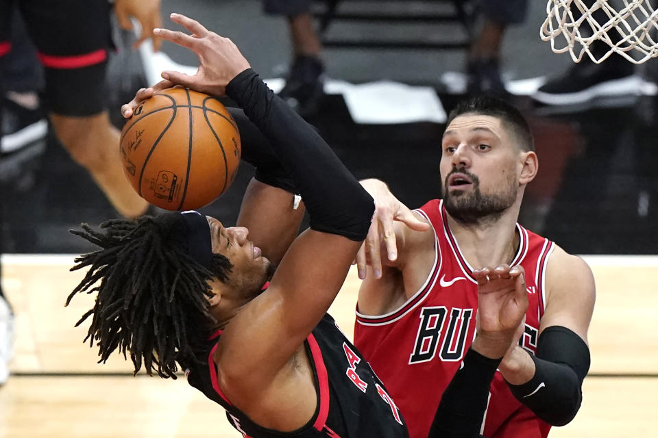 Toronto Raptors forward Freddie Gillespie, left, grabs a rebound next to Chicago Bulls center Nikola Vucevic during the second half of an NBA basketball game in Chicago, Thursday, May 13, 2021. The Bulls won 114-102. (AP Photo/Nam Y. Huh)