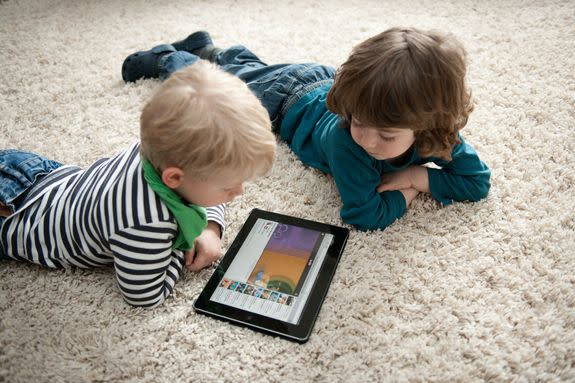 Two little boys watch an animated cartoon on an iPad.