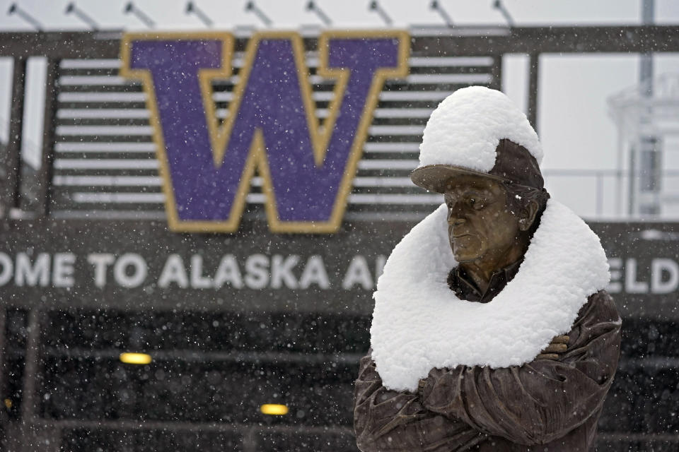 The statue of former Washington NCAA college football coach Don James wears a coating of snow, Saturday, Feb. 13, 2021, in Seattle. Winter weather was expected to continue through the weekend in the region.(AP Photo/Ted S. Warren)