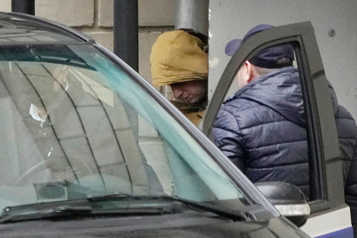 Wall Street Journal reporter Evan Gershkovich is escorted by officers from a courtroom to a bus in Moscow on March 30. He was charged with espionage.