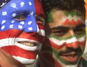 FILE - Mike Moscrop, left, from Orange County, Calif., poses with Amir Sieidoust, an Iranian supporter living in Holland outside the Gerlain Stadium in Lyon, June 21, 1998, before the start of the USA vs Iran World Cup soccer match. Iran defeated the U.S. 2-1 for its first World Cup win, eliminating them after just two games. A rematch between the U.S. and Iran will be played, Tuesday, Nov. 29, 2022. (AP Photo/Jerome Delay)