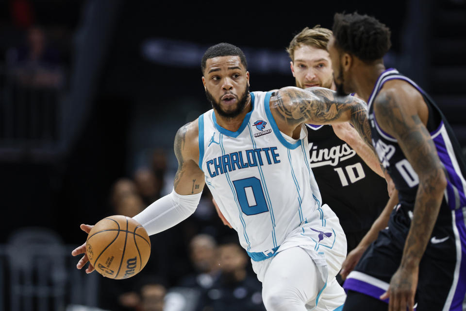 Charlotte Hornets forward Miles Bridges, left, pushes the ball up court against Sacramento Kings guard Malik Monk (0) as forward Domantas Sabonis (10) looks onduring the first half of an NBA basketball game in Charlotte, N.C., Wednesday, Jan. 10, 2024. (AP Photo/Nell Redmond)